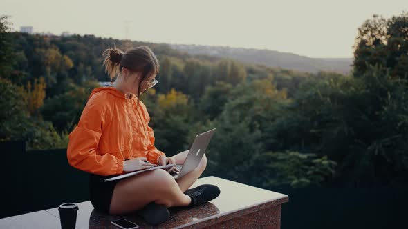 Frame of a Student Who Watches an Online Webinar and Takes Notes in the Middle of Nature alt