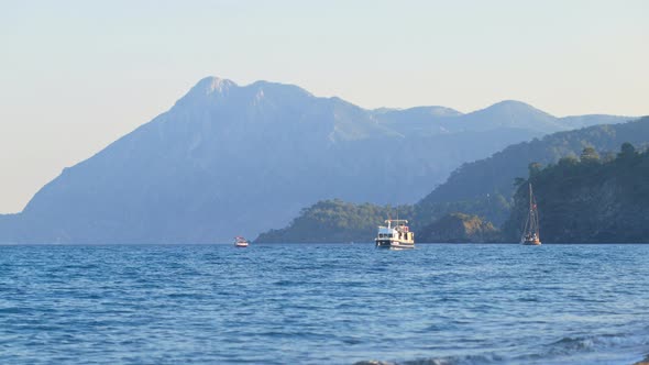 Small Touristic Boat Floating Along Sea Coast, Surf Waves, Sunset, Southern Coast of Turkey