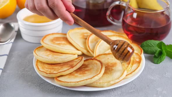 Pancakes. Sweet honey pouring over pancakes. Tasty breakfast food.