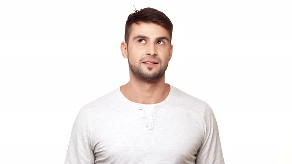 Concentrated Tough Guy in Sweatshirt Standing on White Background Trying to Notice Mosquito and alt