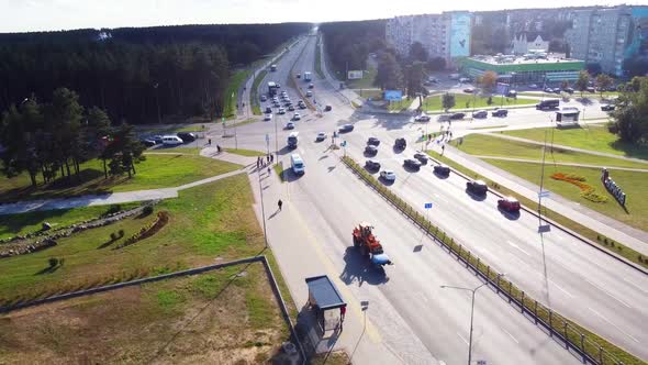 Drone flight over the road in the city where cars and trucks pass alt