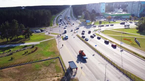 Drone flight over the road in the city where cars and trucks pass