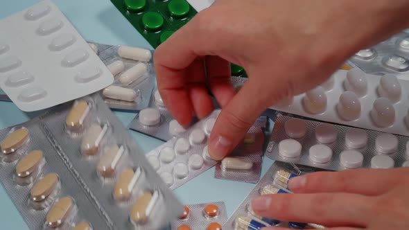 Sick Patient Searches For Pills. On Blue Table alt