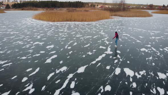 Aerial View. Beautiful Frozen River or Lake. A Man Is Skating on Ice. alt