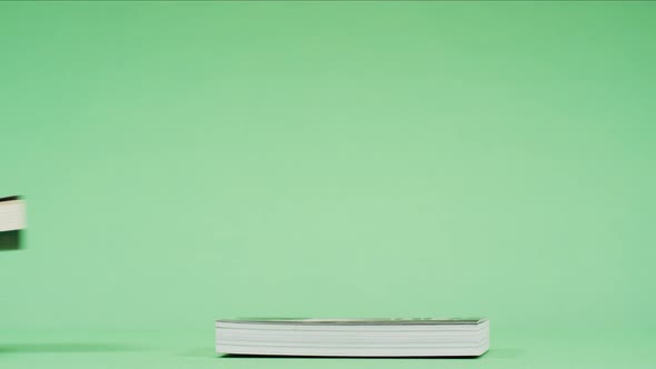 Hand placing books one above the other alt