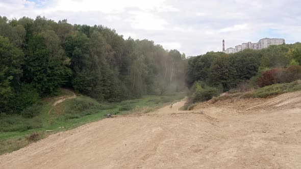 Racer On Sports Motorcycle Rides At High Speed On Dirt Road alt
