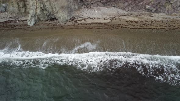 Aerial View From Above on Calm Azure Sea and Volcanic Rocky Shores alt