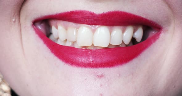 Extreme Close-up Female Mouth with Pink Lipstick Smiling Showing White Healthy Beautiful Teeth