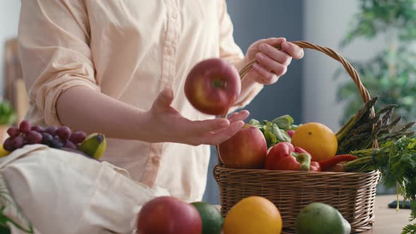 Woman pull in apple and other fruits lying around after the shopping alt