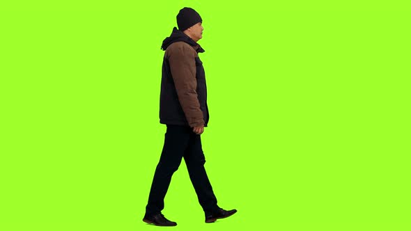Man in Winter Jacket and Hat Walks