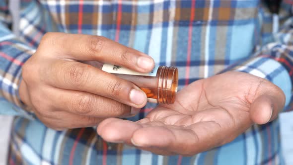 Man's Hand with Medicine Spilled Out of the Pill Container alt
