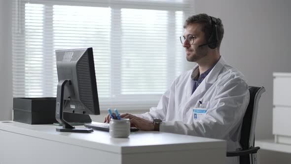 Male Doctor or Nurse with Headset and Computer Working at Hospital alt