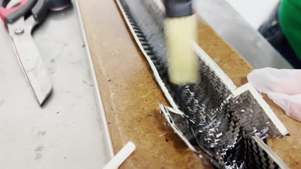 A Specialist in Protective Gloves Covers the Baking Form of a Carbon Product with a Brush with