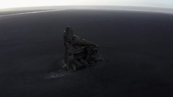 Drone Downward Tilting Shot of Sea Stack in Iceland and Sandy Horizon alt