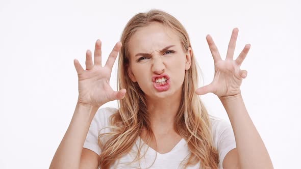 Young Beautiful Caucasian Blonde Girl Trying to Frighten on White Background in Slowmotion alt
