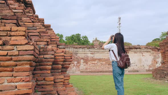 Asian woman using camera for take a picture while spending holiday trip at Ayutthaya,