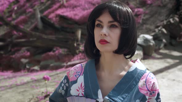 Steadicam Shot of Beautiful Caucasian Woman Dressed Like Japanese Geisha Standing Outdoors on Sakura alt