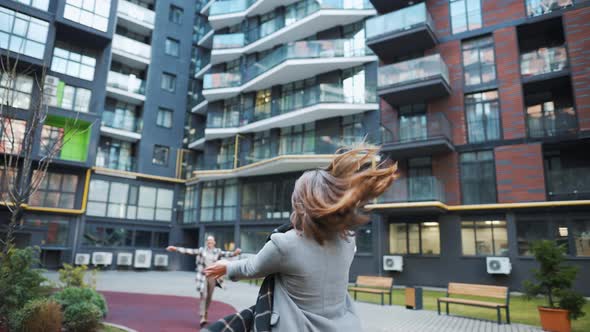 Two Happy Women Hug Each Other When Meeting After Long Separation alt