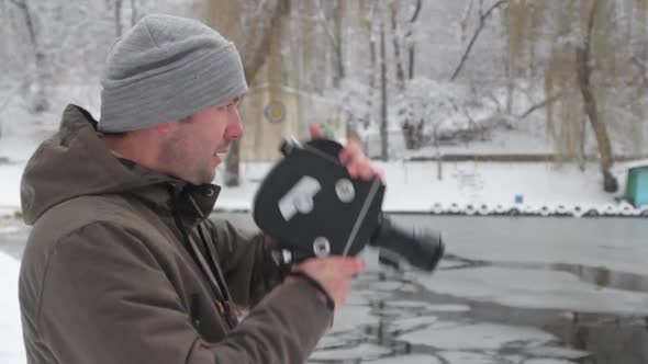 A Male Cameraman Shoots Video on an Old Vintage Camera Krasnogorsk in the Park in Winter. Kyiv alt