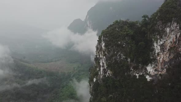 An Aerial View of Green Mountains During the Rain Between the Clouds in Thailand