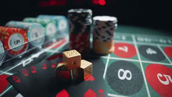 Casino Chips with Dice and Playing Cards on a Dark Table alt