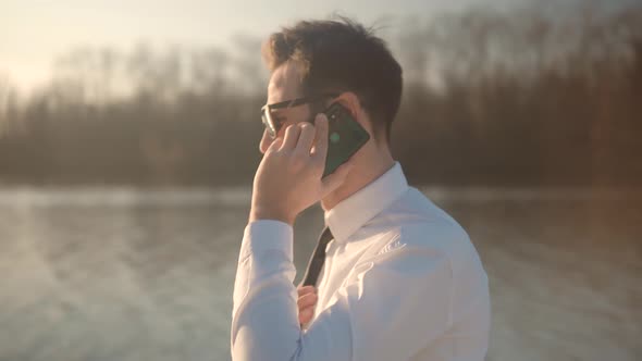 Businessman Talking On Phone.Attractive Young Businessman In Sunglasses Using Mobile Phone And Call. alt
