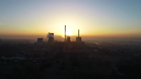 Aerial sunrise view of big powerhouse. Drone flight into to power plant