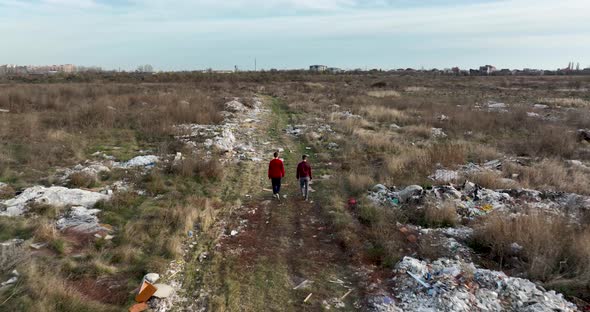 Two People Walking on a Huge Aste Garbade Dump Rubbish Landill in Bucharest