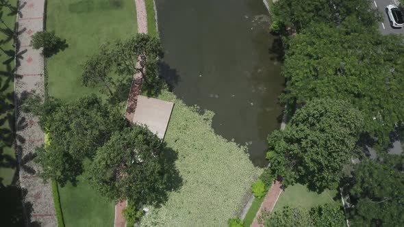 aerial view of modern urban park featuring lakes, lush gardens, bridges, green space, pathways and t alt