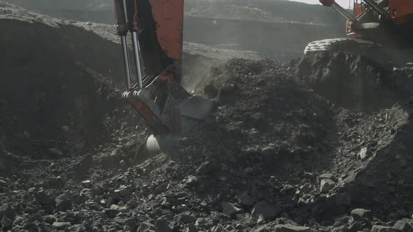 Bucket of Mining Excavator Scoops Up Coal From Deposit Close Up View