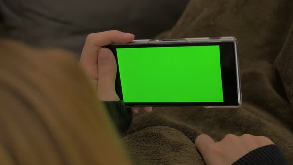Woman scrolling through pages on green screen smart phone 4K 2160p UHD video - Green display on mobi