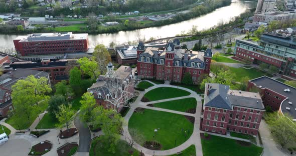 Downtown Morgantown and historic WVU campus buildings. Woodburn Hall and Monongahela River at sunset alt
