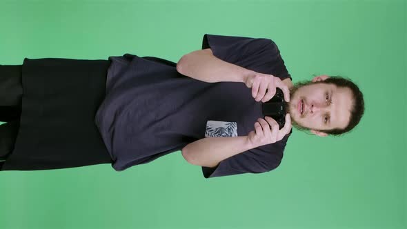 Portrait of a Tense Young Man Playing a Video Game with a Wireless Controller Rejoicing at the alt