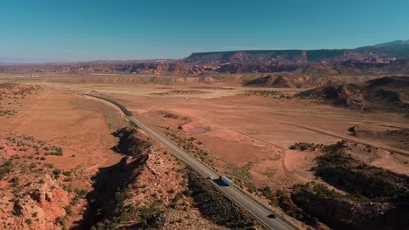 Drone view of road in desert with traffic near Moab alt