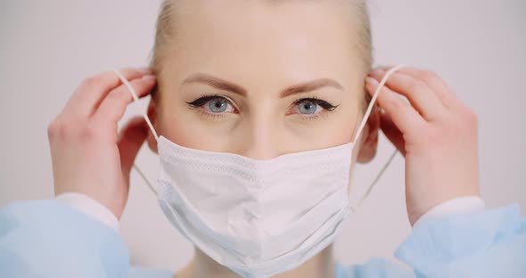 Woman Put Protective Mask on Face alt