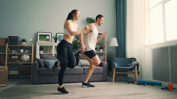 Young Girl and Guy in Sportswear Running at Home Doing Sports Together Training alt