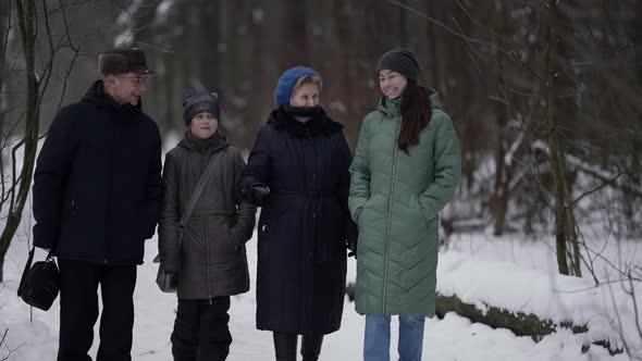 Little Girl and Her Mother and Grandparents are Walking in Park at Winter Happy Family alt