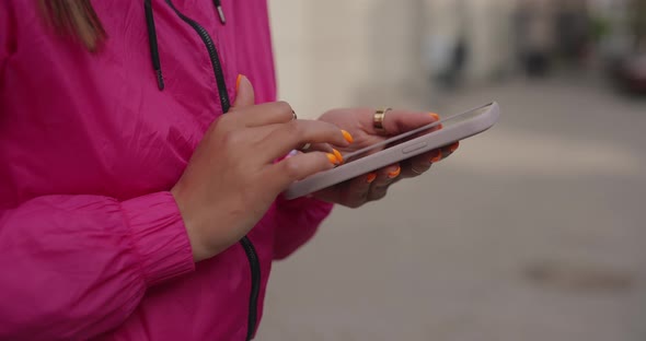 Hands of Sporty Woman Choose Music in Smartphone alt