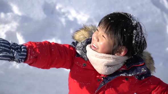 Cute Asian Child Wearing Winter Clothes Playing On Snow In The Park alt