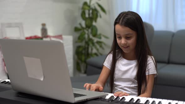 Christmas Time Laptop on Piano Keys Little Girl Playing Piano alt