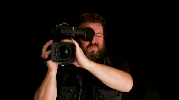 Concept idea: Bearded TV cameraman with professional video camera