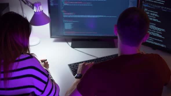 Two Smart Young Programmers are Coding on Computer in Process of Discussion alt