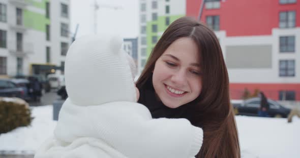 Smiling Mother Girl Holding Baby In Her Arms On A Winter Walk