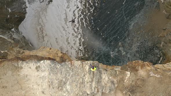 Top View of a Brave Man Jumps Into the Tuimsky Sinkhole on a Bungee.