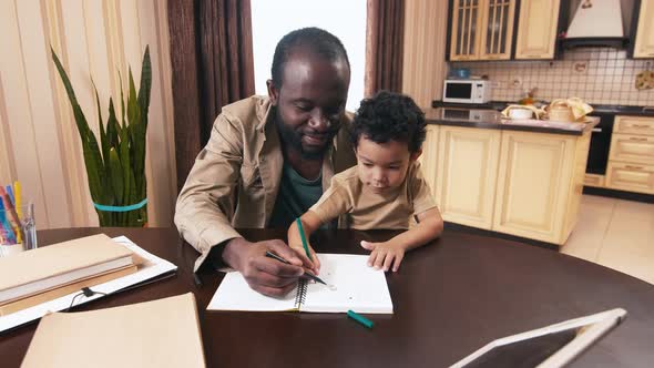 African American dad drawing with his biracial kid