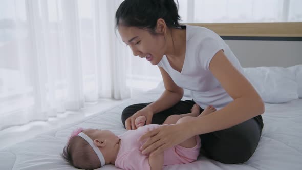 Family concept. The mother teased the baby in the bedroom. 4k Resolution alt