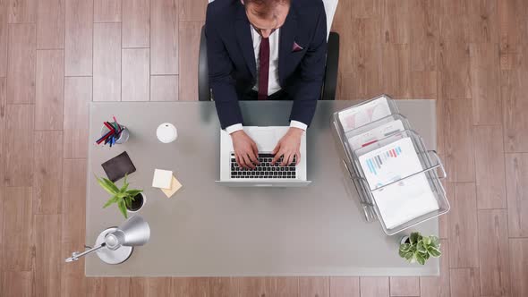 Top View of Young Businessman Typing on His Laptop alt