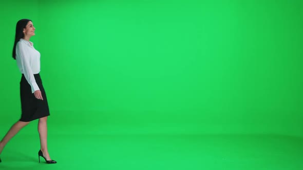 Young Businesswoman in a Suit Walks on a Green Background Chroma Key Template alt