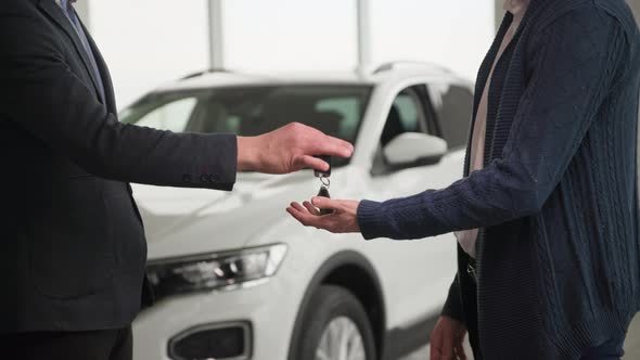 Successful Deal Joyful Male Owner of a New Vehicle Takes Keys to a New Automobile and Shakes Hands