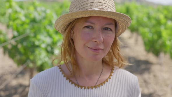 Headshot Confident Beautiful Caucasian Woman in Straw Hat Standing in Sunshine Outdoors Looking at alt